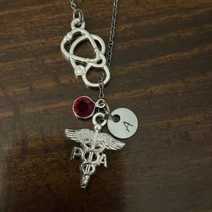 Silver pendant necklace for medical workers. Garnet, letter A, PA emblem.
